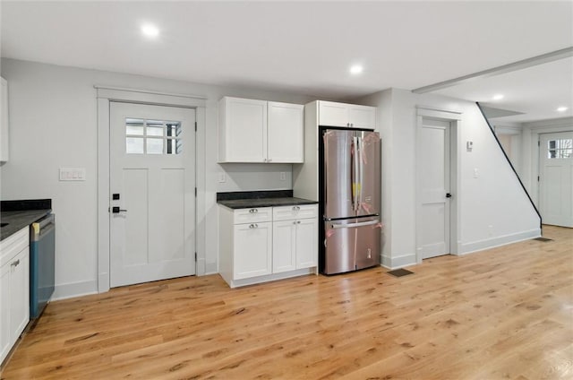 kitchen with white cabinets, stainless steel appliances, and light hardwood / wood-style floors