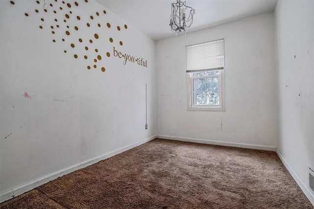 carpeted spare room featuring a notable chandelier