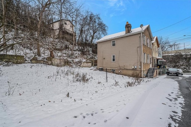 view of snow covered rear of property