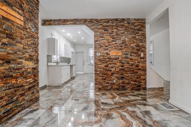 kitchen featuring white cabinetry, decorative backsplash, and sink