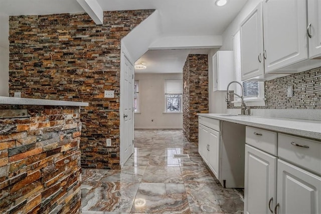 kitchen featuring white cabinetry, sink, and a healthy amount of sunlight