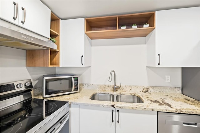 kitchen with light stone counters, sink, white cabinets, and stainless steel appliances