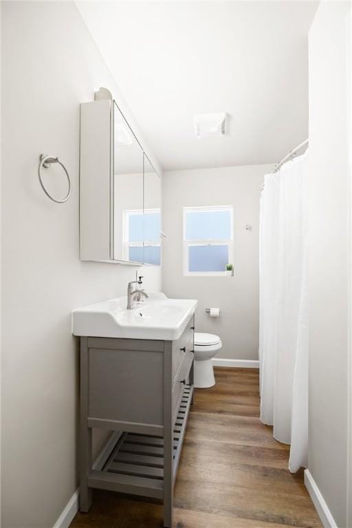 bathroom featuring hardwood / wood-style floors, vanity, toilet, and a wealth of natural light