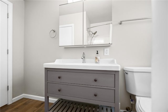 bathroom with wood-type flooring, vanity, and toilet