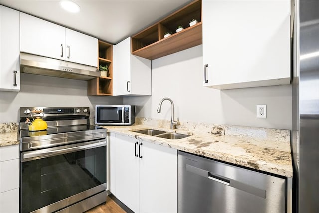 kitchen with light stone countertops, sink, white cabinets, and appliances with stainless steel finishes