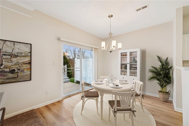 dining space with a chandelier and light wood-type flooring