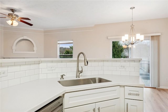 kitchen featuring white cabinets, tasteful backsplash, hanging light fixtures, and sink