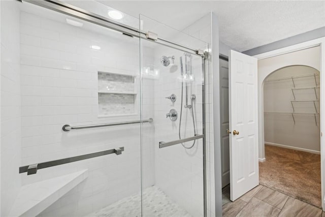 bathroom featuring a textured ceiling and walk in shower