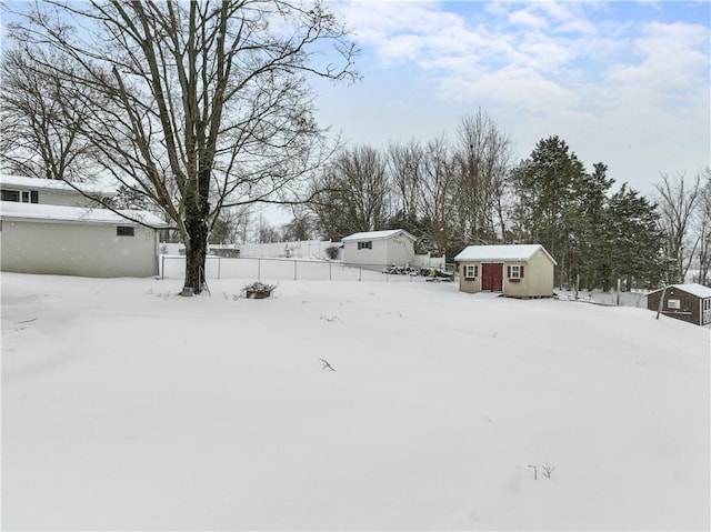 yard layered in snow with an outbuilding