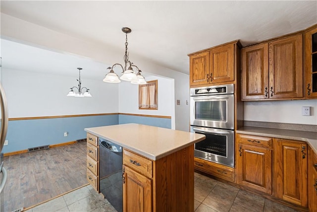 kitchen featuring an inviting chandelier, stainless steel double oven, decorative light fixtures, dishwasher, and a center island