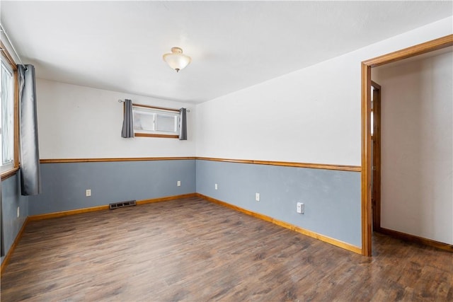 unfurnished room with dark wood-type flooring