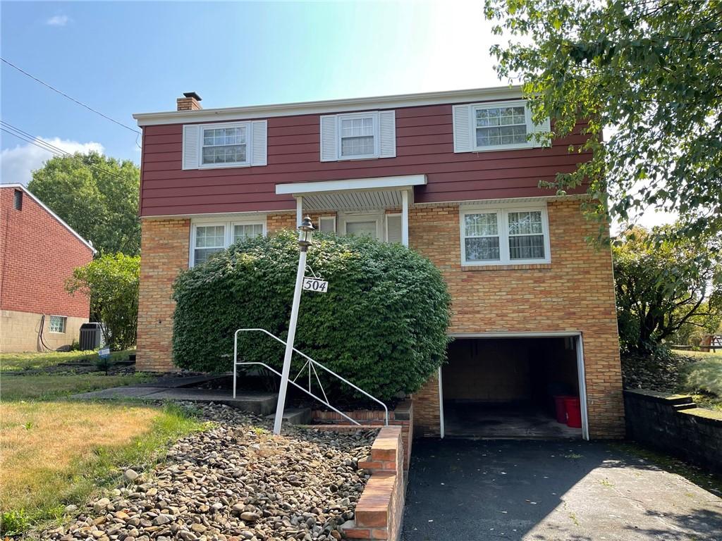 view of front of home featuring central AC unit and a garage