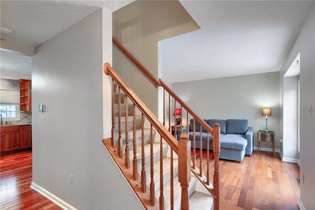 stairway featuring sink and wood-type flooring