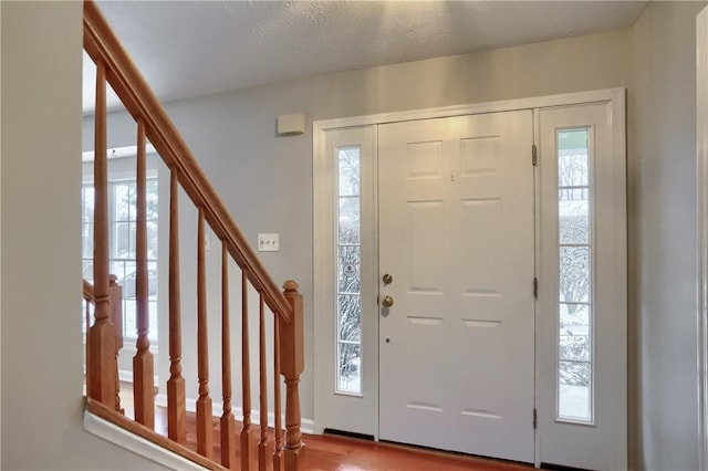 entrance foyer with hardwood / wood-style floors and a textured ceiling