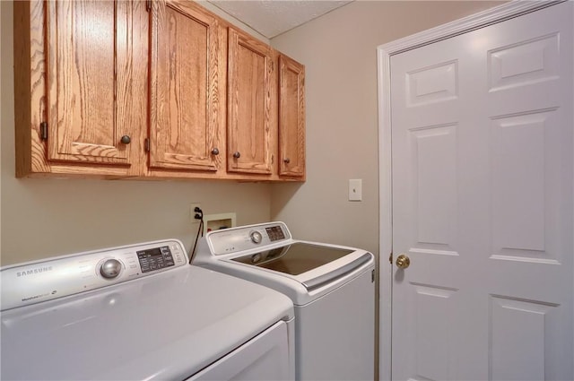 clothes washing area featuring cabinets and independent washer and dryer