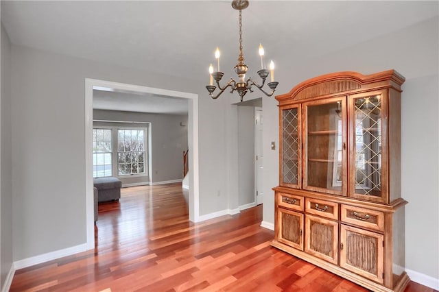 unfurnished dining area featuring hardwood / wood-style floors and a chandelier