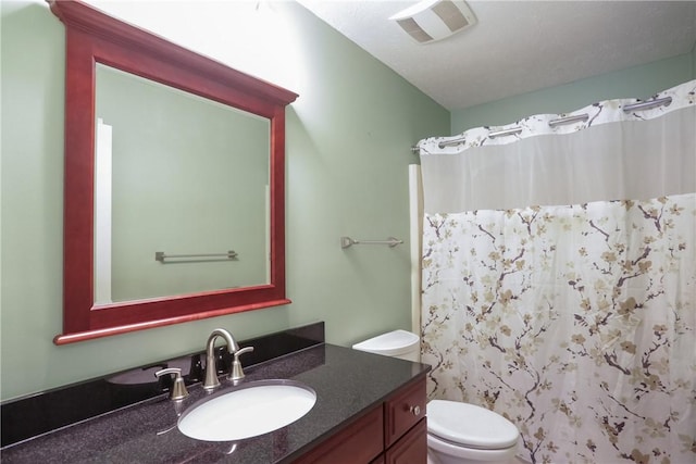 bathroom featuring vanity, curtained shower, and toilet