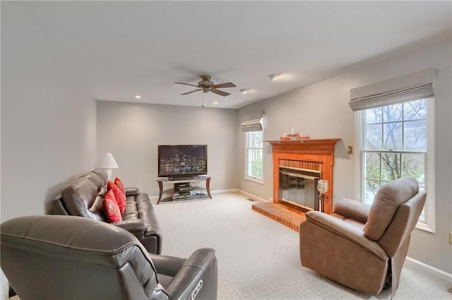 living room with ceiling fan, light colored carpet, and a brick fireplace