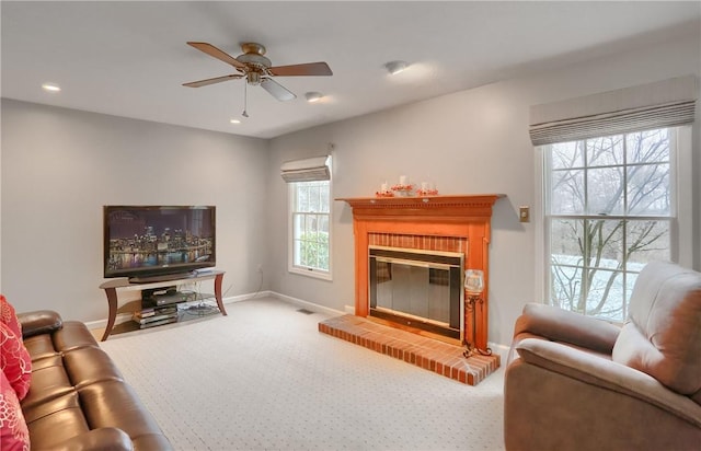 carpeted living room featuring ceiling fan and a brick fireplace