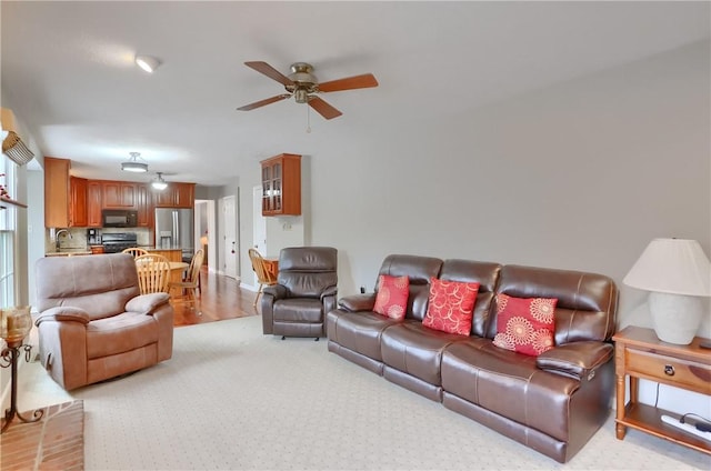 living room featuring ceiling fan and sink