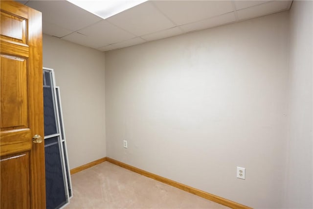 empty room featuring light colored carpet and a drop ceiling