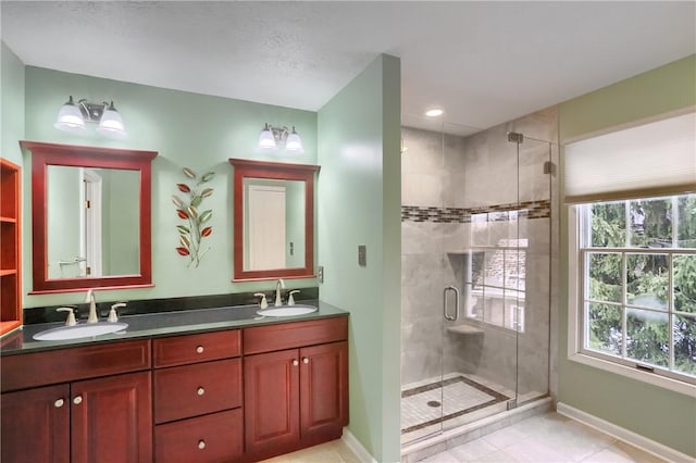 bathroom featuring a shower with door, vanity, and tile patterned flooring