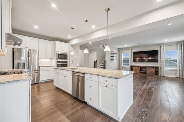 kitchen with pendant lighting, white cabinets, extractor fan, and appliances with stainless steel finishes