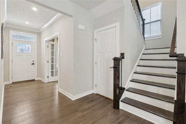 entrance foyer with dark hardwood / wood-style flooring and crown molding