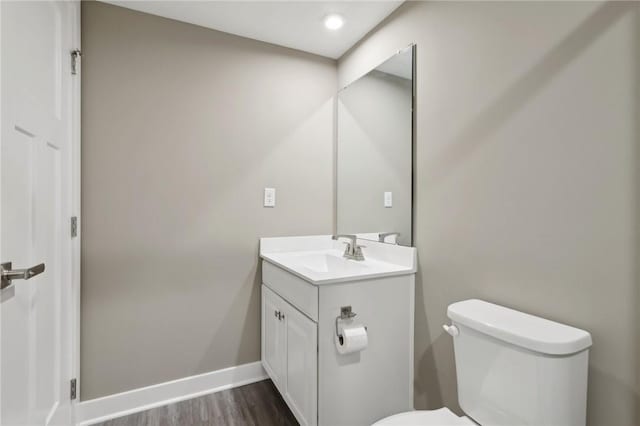 bathroom with vanity, toilet, and wood-type flooring