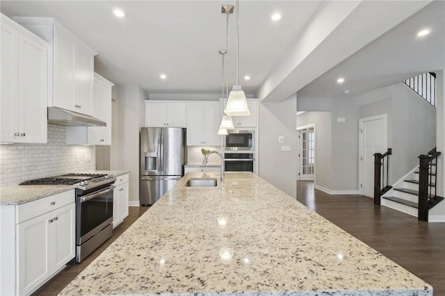 kitchen with white cabinetry, sink, stainless steel appliances, a spacious island, and pendant lighting