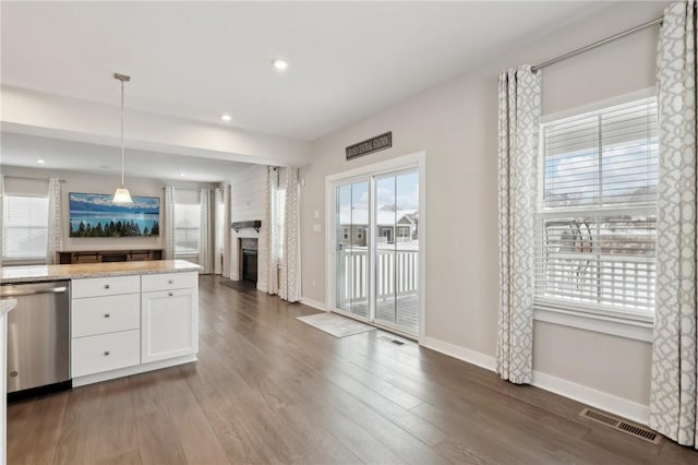 kitchen with dark hardwood / wood-style flooring, white cabinets, light stone counters, pendant lighting, and dishwasher