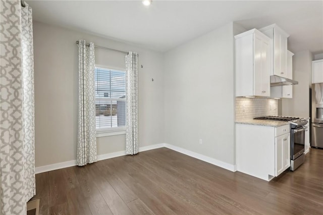 kitchen featuring white cabinets, backsplash, appliances with stainless steel finishes, and dark wood-type flooring