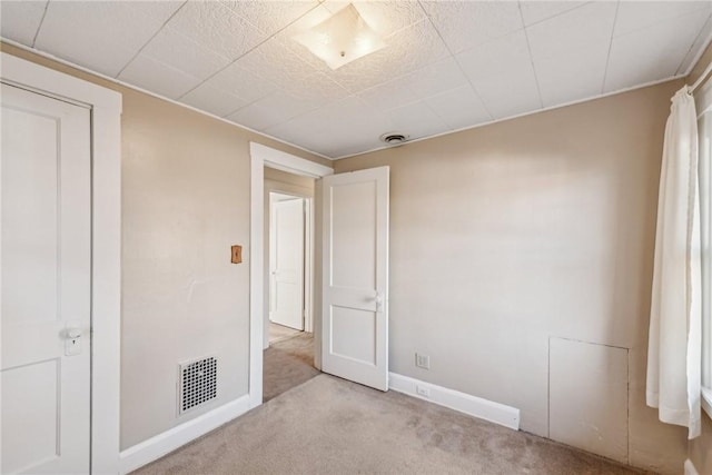 unfurnished bedroom featuring a closet and light colored carpet