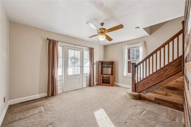 carpeted foyer entrance with a wealth of natural light and ceiling fan