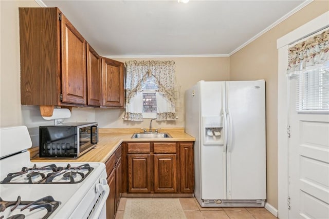 kitchen featuring sink, light tile patterned floors, white appliances, and ornamental molding