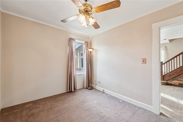 carpeted spare room with ceiling fan and ornamental molding