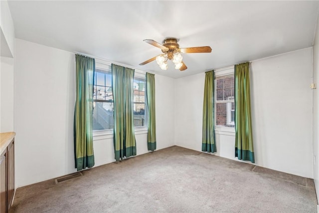 unfurnished room featuring ceiling fan and carpet