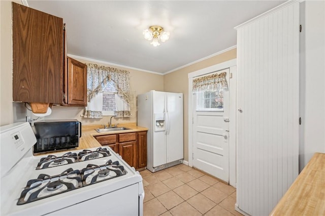 kitchen with crown molding, white appliances, sink, and light tile patterned floors