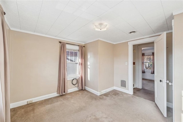 carpeted spare room featuring crown molding