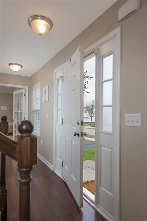 entryway featuring an AC wall unit and dark wood-type flooring