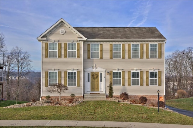 colonial-style house featuring a front yard