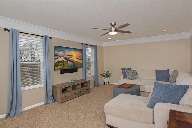 carpeted living room with a wealth of natural light, ceiling fan, and ornamental molding