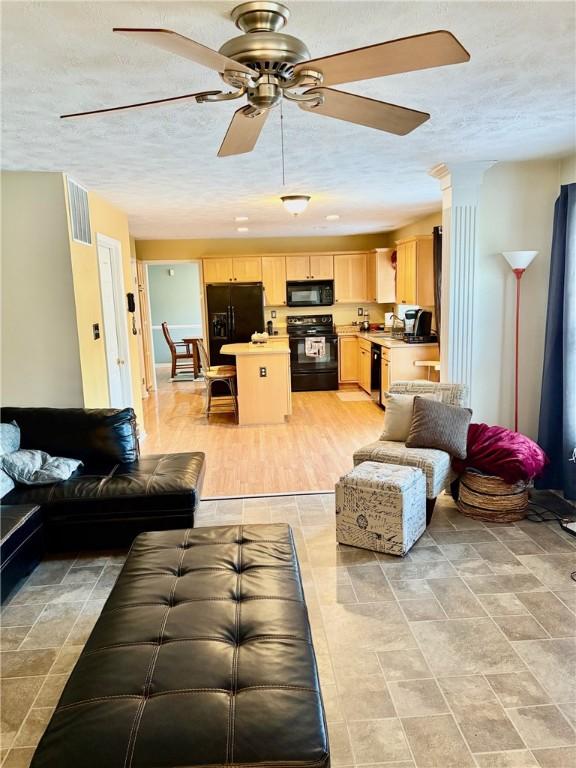 living room with a textured ceiling and ceiling fan