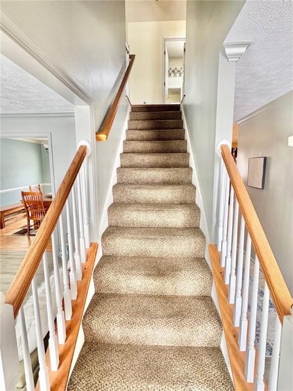 stairs featuring hardwood / wood-style flooring and a textured ceiling