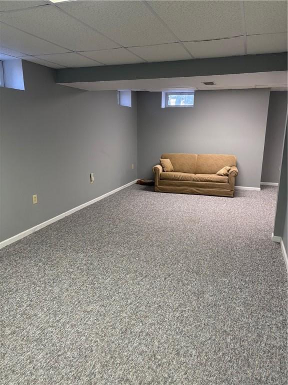 basement with carpet flooring and a paneled ceiling