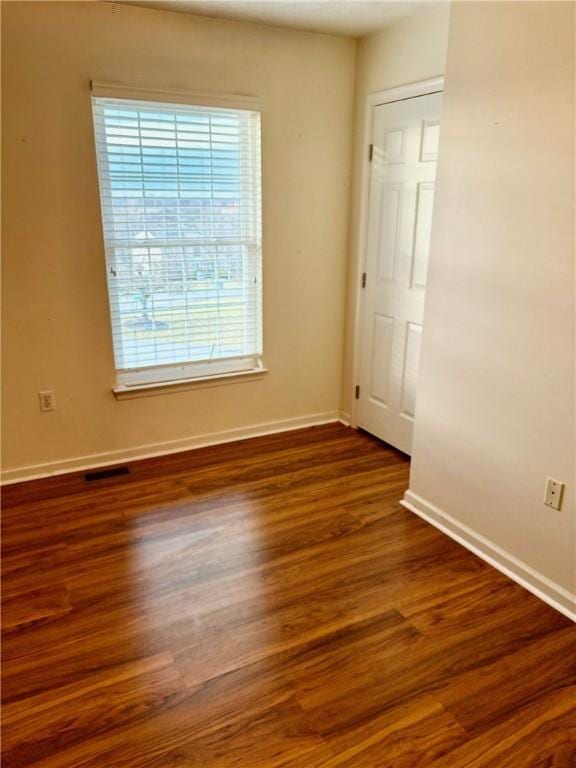 spare room with dark hardwood / wood-style flooring