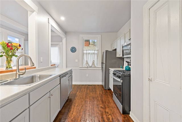 kitchen featuring dark hardwood / wood-style floors, sink, white cabinetry, and stainless steel appliances