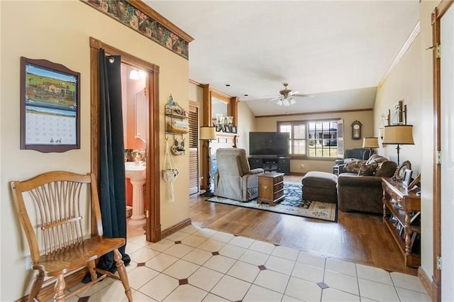 tiled living room with ceiling fan, crown molding, and lofted ceiling