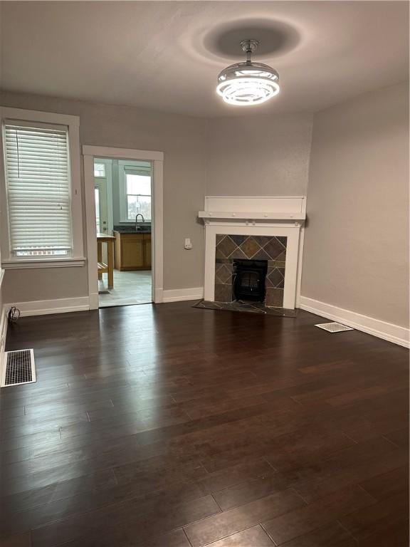 unfurnished living room featuring dark hardwood / wood-style floors, sink, and a fireplace