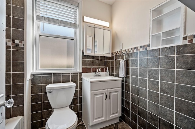 bathroom featuring vanity, toilet, and tile walls